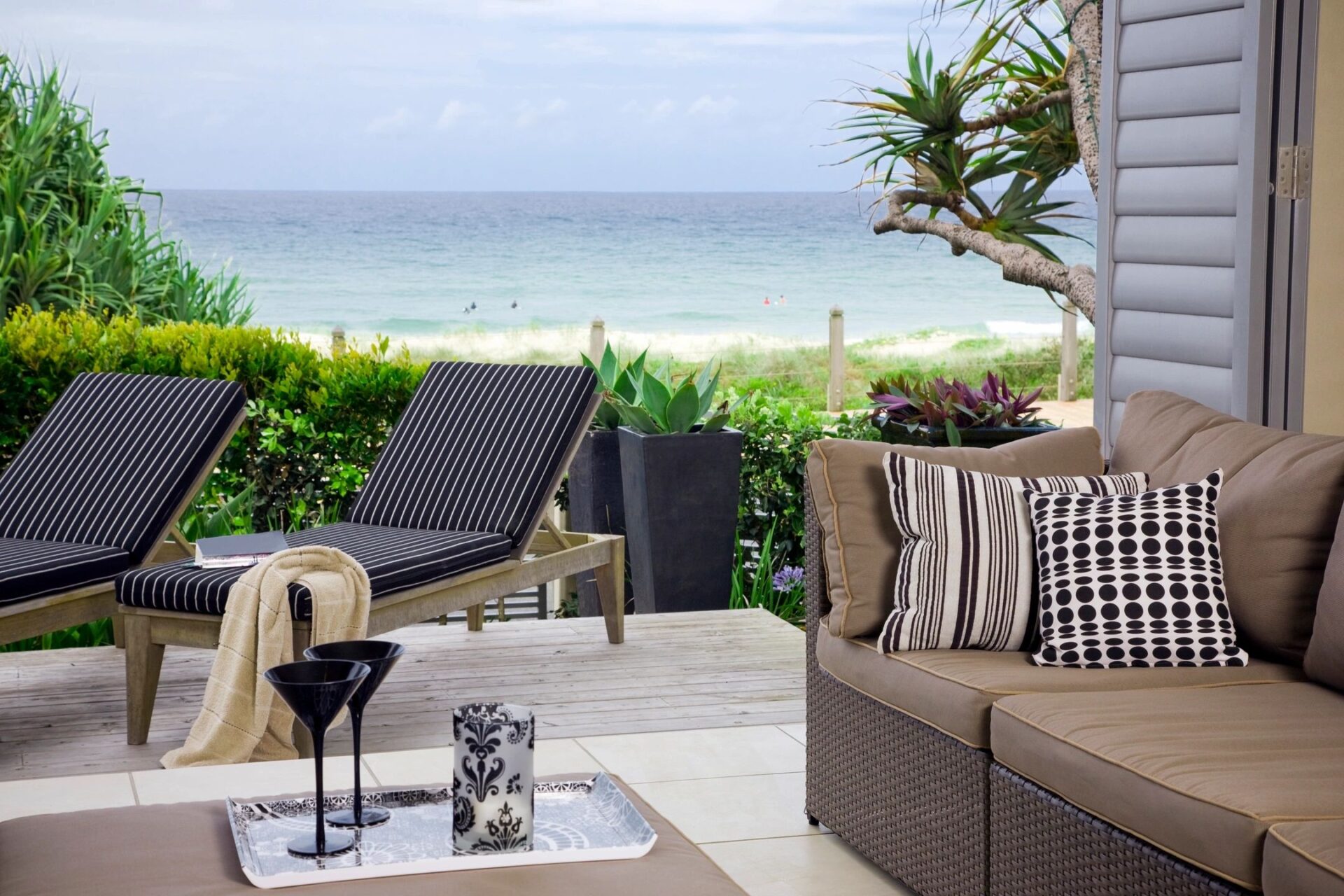 A patio with chairs and tables on the beach